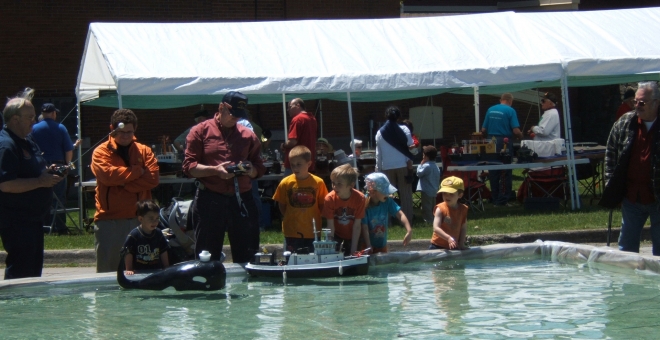 Kids playing with radio-controlled boats