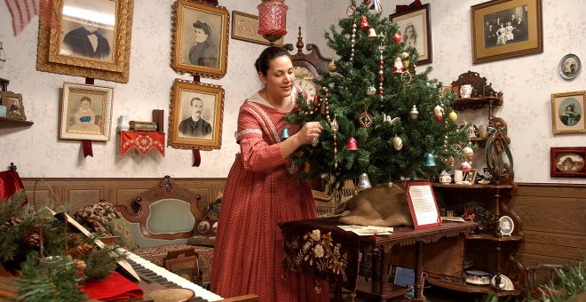 Interpreter in Victorian dress decorating the Christmas tree. 