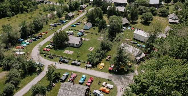 Aerial view of historic village with lots of antique vehicles on display